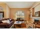Inviting living room with a fireplace, arched windows and a cozy seating arrangement at 3538 E Squawbush Pl, Phoenix, AZ 85044