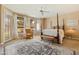 Spacious main bedroom with a four-poster bed, ceiling fan and large windows at 3538 E Squawbush Pl, Phoenix, AZ 85044