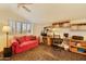 Cozy office features a comfortable sofa, a built-in desk, and plenty of natural light from a window at 3538 E Squawbush Pl, Phoenix, AZ 85044