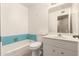 Vintage bathroom with a blue-tiled bathtub, toilet, and vanity with sink at 3632 W Mariposa St, Phoenix, AZ 85019