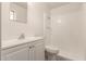 Well-lit bathroom featuring a modern vanity, toilet, and a shower with tiled walls at 3632 W Mariposa St, Phoenix, AZ 85019