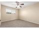 Cozy bedroom featuring a ceiling fan, a window, and neutral carpet at 3632 W Mariposa St, Phoenix, AZ 85019