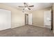Comfortable bedroom with a ceiling fan, carpet flooring, and access to an ensuite bathroom and closet space at 3632 W Mariposa St, Phoenix, AZ 85019