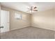 Cozy bedroom featuring a ceiling fan, plush carpet, and a large window for plenty of natural light at 3632 W Mariposa St, Phoenix, AZ 85019