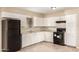 Clean kitchen with black appliances, white cabinets, granite countertop, and tile floors offers a stylish cooking space at 3632 W Mariposa St, Phoenix, AZ 85019
