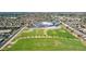 Expansive aerial view featuring lush green fields, a modern school building, and a neighborhood of single-Gathering homes at 3724 E Derringer Way, Gilbert, AZ 85297