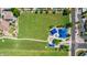 Beautiful aerial view of a park with lush green grass, vibrant blue shade structures, and a playground for Gathering enjoyment at 3724 E Derringer Way, Gilbert, AZ 85297