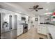 Modern kitchen with stainless steel appliances, white cabinets, sleek countertops, and a ceiling fan at 39 E Tam Oshanter Dr, Phoenix, AZ 85022