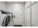 Modern laundry room with front-load washer and dryer, built-in cabinets, and a door at 39 E Tam Oshanter Dr, Phoenix, AZ 85022