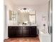 Bright bathroom featuring a double sink vanity with storage, and a bathtub with white tile surround at 4038 E Wagon Cir, Gilbert, AZ 85297