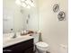 Half bath features a dark wood vanity with single sink, and a low-flow toilet at 4038 E Wagon Cir, Gilbert, AZ 85297