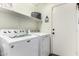 Bright laundry room includes washer, dryer, storage shelf, and door to the exterior at 4038 E Wagon Cir, Gilbert, AZ 85297