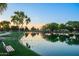 Scenic community pond reflects the sky with trees, a bench and walking path at 4038 E Wagon Cir, Gilbert, AZ 85297