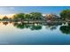 Community pond reflecting a charming lakeside clubhouse with a fountain at 4038 E Wagon Cir, Gilbert, AZ 85297