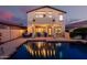Backyard pool with lighting, lush landscaping, and patio with seating at 4038 E Wagon Cir, Gilbert, AZ 85297