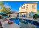 Inviting backyard pool with lounge chairs, covered patio, and beautiful landscaping at 4038 E Wagon Cir, Gilbert, AZ 85297