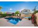 Backyard pool and patio area includes a spa, seating, and surrounding greenery at 4038 E Wagon Cir, Gilbert, AZ 85297