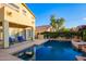 Backyard pool featuring a covered patio and lush green landscape surrounding the home at 4038 E Wagon Cir, Gilbert, AZ 85297