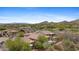 Aerial view of single Gathering home and backyard pool and green desert community with mountain views at 41627 N Cedar Chase Rd, Anthem, AZ 85086