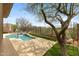 View of the backyard pool and spa with privacy fence, lush green faux grass and mature landscaping at 41627 N Cedar Chase Rd, Anthem, AZ 85086