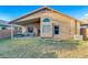 Backyard featuring a covered patio, lush green lawn, and a well-maintained exterior at 4605 W Fawn Dr, Laveen, AZ 85339