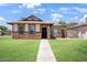 Home exterior featuring a green lawn, brick accents, and desert landscaping at 5135 E Evergreen St # 1159, Mesa, AZ 85205