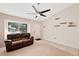 A well-lit living room includes a large window, ceiling fan, and comfortable leather seating at 5135 E Evergreen St # 1159, Mesa, AZ 85205
