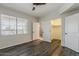 Large bedroom featuring wood floors, white walls, a ceiling fan, and access to an ensuite bathroom and walk-in closet at 5302 E Van Buren St # 3040, Phoenix, AZ 85008