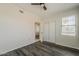 This bedroom features a dark ceiling fan, wood floors, neutral colored walls, and closet at 5302 E Van Buren St # 3040, Phoenix, AZ 85008