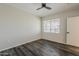 This bedroom features a dark ceiling fan, wood floors, neutral colored walls, and a sunlit window at 5302 E Van Buren St # 3040, Phoenix, AZ 85008