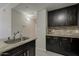 This kitchen features dark cabinets, granite countertops, tile backsplash, and stainless steel sink at 5302 E Van Buren St # 3040, Phoenix, AZ 85008