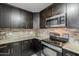 Kitchen featuring dark wood cabinets, stainless steel appliances, and granite countertops at 5302 E Van Buren St # 3040, Phoenix, AZ 85008