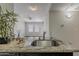 The kitchen showcases granite countertops and a stainless steel sink, with a view into a living area with a ceiling fan and bright windows at 5302 E Van Buren St # 3040, Phoenix, AZ 85008