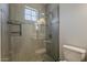 Beautifully tiled walk-in shower featuring a glass door, shower head, and built-in shelving at 5302 E Van Buren St # 3040, Phoenix, AZ 85008
