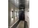 Bright hallway featuring modern lighting fixtures, leading into the living area, and mosaic rug on black tiled flooring at 6803 E Main St # 4415, Scottsdale, AZ 85251