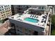 Aerial view of a rooftop pool and lounge area with seating, umbrellas, and a hot tub at 6803 E Main St # 4415, Scottsdale, AZ 85251