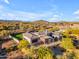 Aerial view of a desert home highlights the lush landscaping and mountain views from this unique vantage point at 7130 E Navarro Way, Scottsdale, AZ 85266