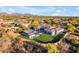 Aerial view of modern estate showcasing a pool with cabana, turf lawn, desert landscaping, and mountain views at 7130 E Navarro Way, Scottsdale, AZ 85266
