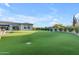 Vast backyard with artificial turf, complemented by mature trees and well-maintained landscaping at 7130 E Navarro Way, Scottsdale, AZ 85266