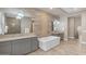 Stylish bathroom featuring a soaking tub, dual vanities, elegant lighting, and upscale finishes at 7130 E Navarro Way, Scottsdale, AZ 85266