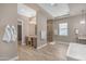 Luxurious bathroom featuring a spacious shower, soaking tub, and a vanity area with stylish fixtures and wood look flooring at 7130 E Navarro Way, Scottsdale, AZ 85266