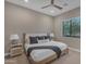 Bright bedroom features a large window, a ceiling fan, and a comfortable bed with stylish pillows and blankets at 7130 E Navarro Way, Scottsdale, AZ 85266