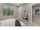 Bedroom with a large window, full-length mirror reflecting the room, and doorways leading to other spaces at 7130 E Navarro Way, Scottsdale, AZ 85266