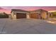 Three car garage with concrete driveway, exterior lighting, and desert landscaping at 7130 E Navarro Way, Scottsdale, AZ 85266