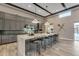 A modern kitchen with grey cabinets, quartz countertops, and an island with barstool seating at 7130 E Navarro Way, Scottsdale, AZ 85266