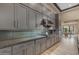 Stylish kitchen with gray cabinets, stainless steel appliances, and textured backsplash at 7130 E Navarro Way, Scottsdale, AZ 85266