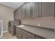 Laundry room with gray cabinets, a sink, and stainless steel washer and dryer, offering convenience and style at 7130 E Navarro Way, Scottsdale, AZ 85266