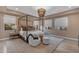 Stylish main bedroom with a four-poster bed, designer lighting, neutral tones and ample natural light at 7130 E Navarro Way, Scottsdale, AZ 85266