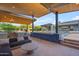 Outdoor kitchen and lounge under wood pergola, featuring a barbecue, seating and pool view at 7130 E Navarro Way, Scottsdale, AZ 85266