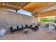 Inviting outdoor living area with sectional sofa, outdoor kitchen, and stone accent wall at 7130 E Navarro Way, Scottsdale, AZ 85266